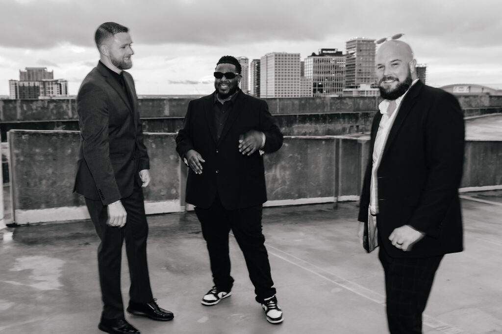 Three DJs from Graingertainment standing and laughing atop a Tampa, Florida building