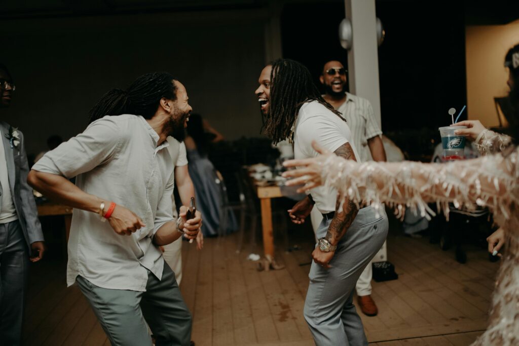 Two groomsmen dancing to a wedding playlist