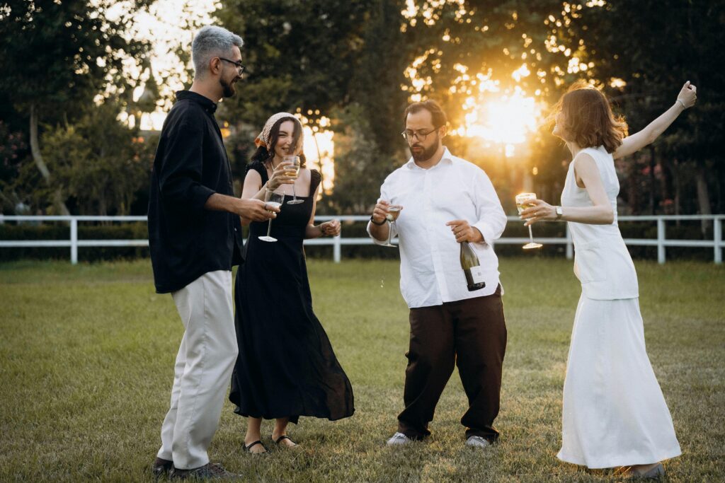 Wedding guests dance on the grass during cocktail to an amazing wedding playlist